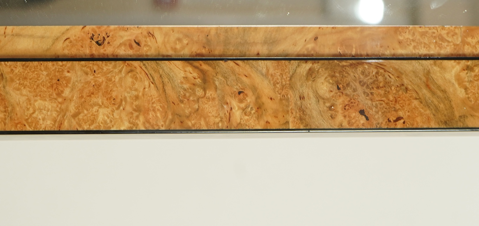 An Art Deco style sweetgum veneered rectangular overmantel mirror
